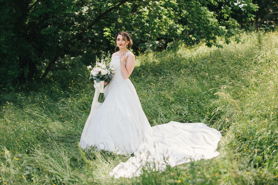 full length shot of bride in a field holding bouquet made by lipinoga florist