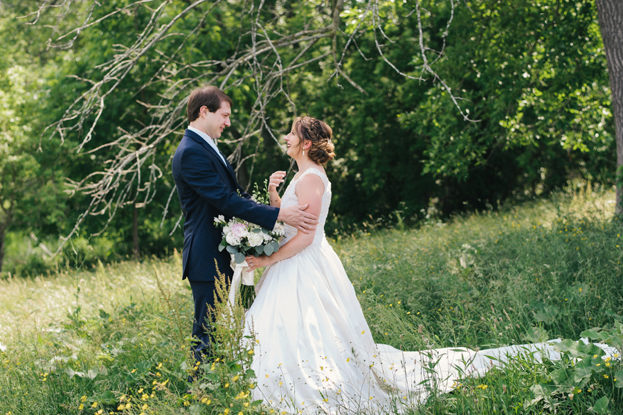 bride and groom having first look in a field