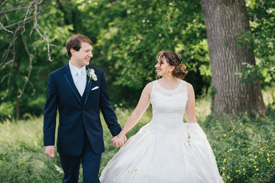 bride and groom holding hands and smiling at each other