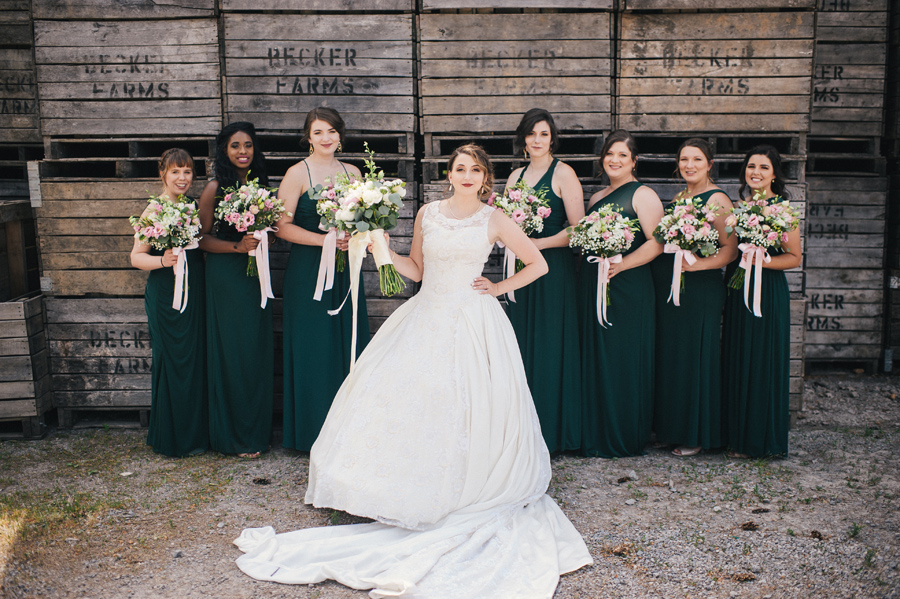 bride looking sassy with bridal party in front of crates at becker farms