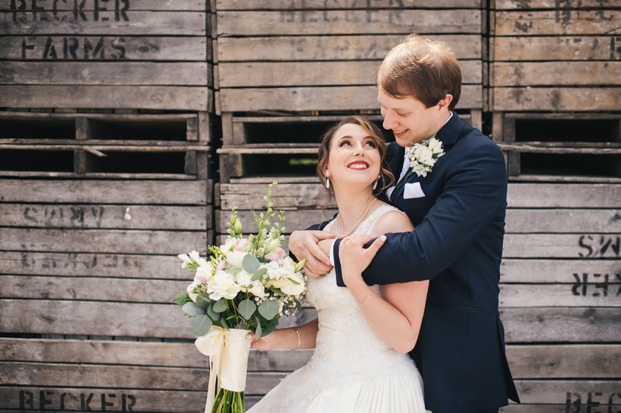 bride gazing up at groom as he stands with his arms around her