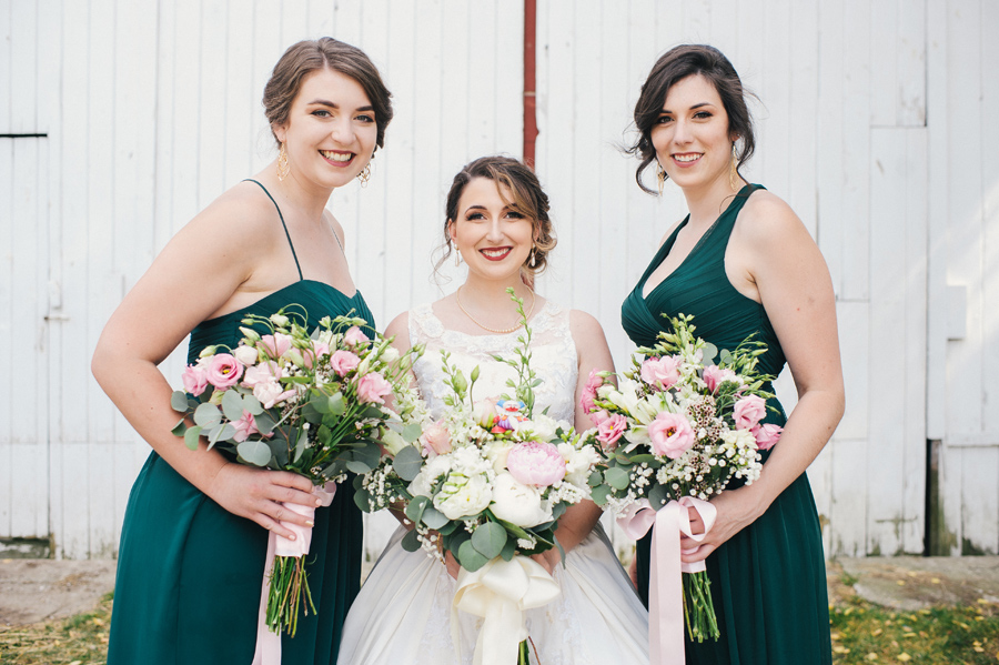 bride and 2 bridesmaids smiling and holding bouquets