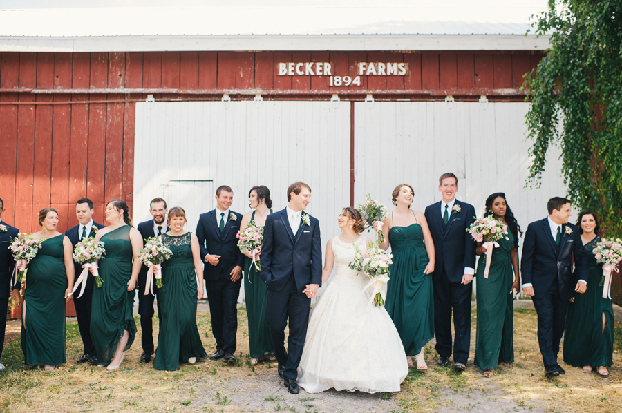bridal party in front of becker farms barn walking towards camera