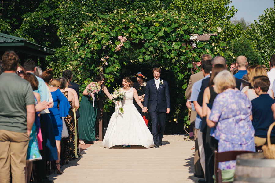 bride and groom holding hands and walking up the aisle after ceremony