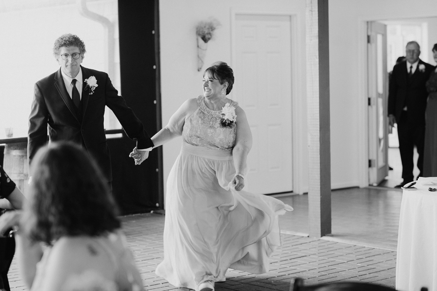 black and white of bride's parents entering reception