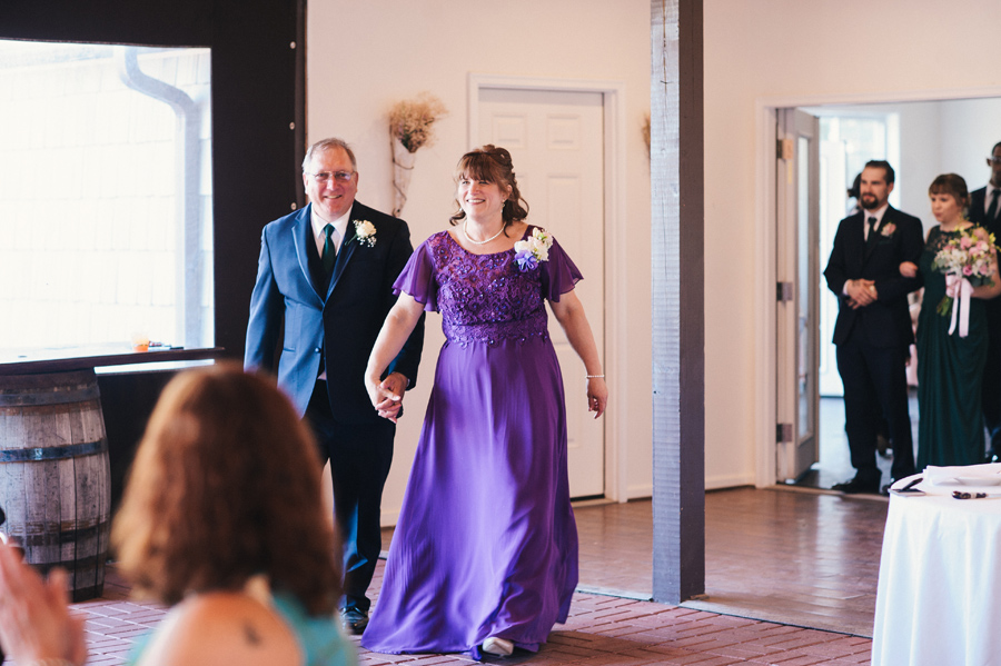 groom's parent's entering reception party hand in hand