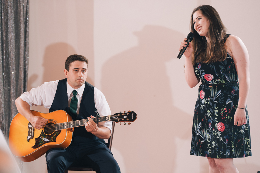 man playing guitar and woman singing