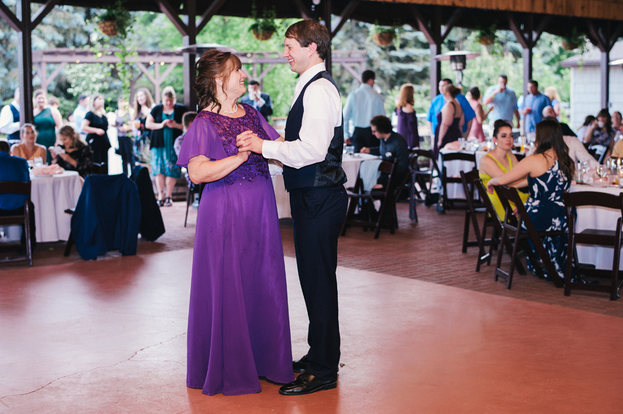 groom and his mother smiling at each other as mother son dance begins