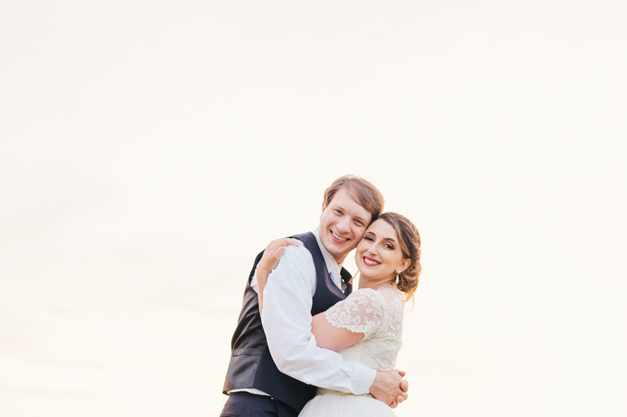 bride and groom hugging and smiling at the camera