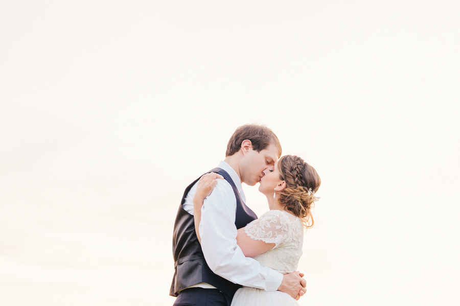 bride and groom outside kissing