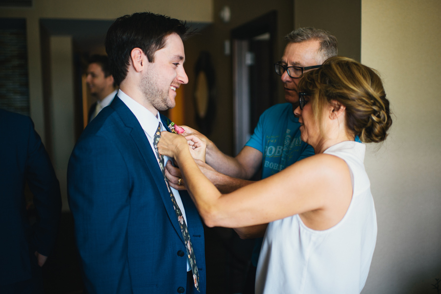 mother and father of the groom pinning boutonniere