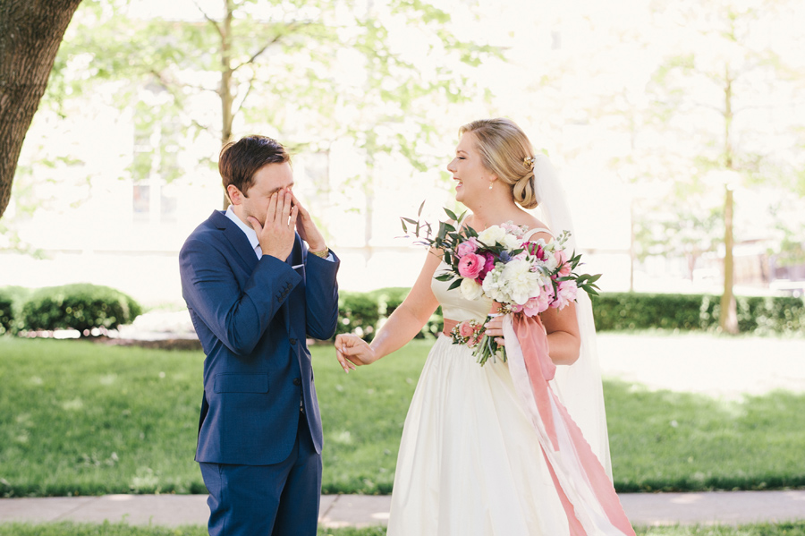 groom rubbing his eyes during the first look