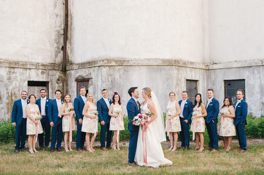 bridal party lined up in front of grain silos