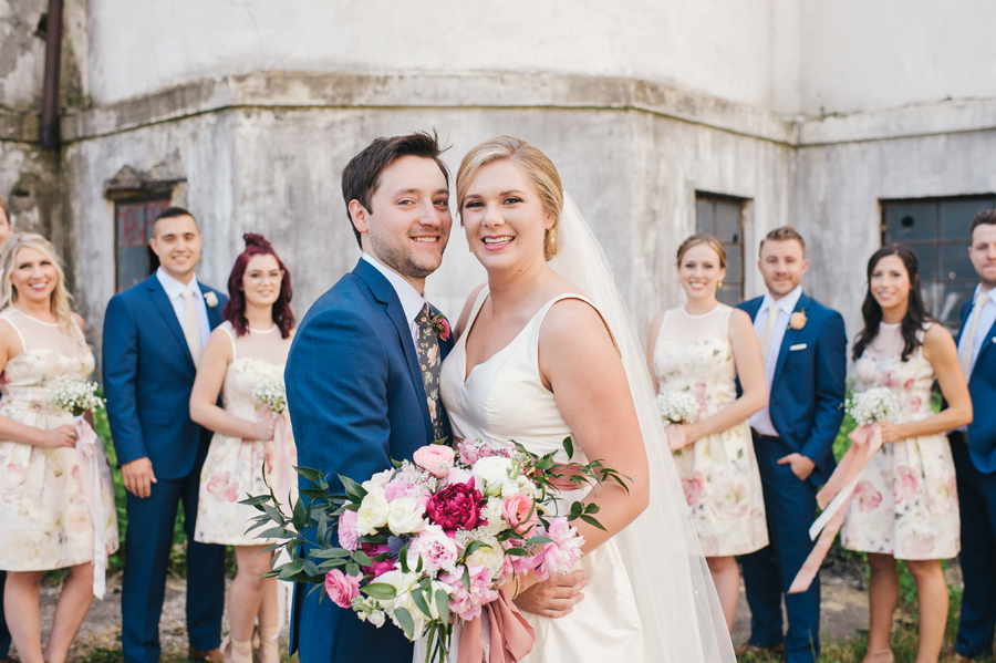 bride and groom smiling in front of silo city