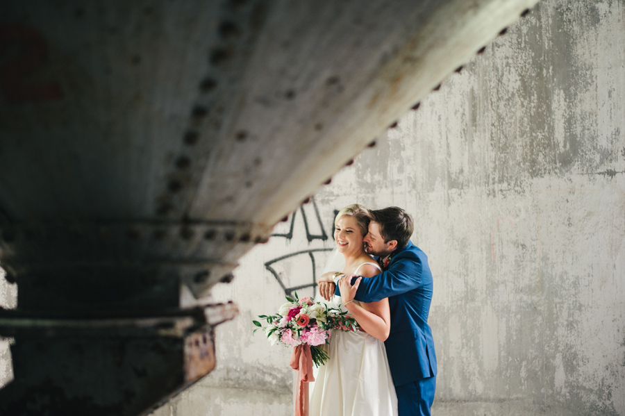 groom hugging bride under a grain silo