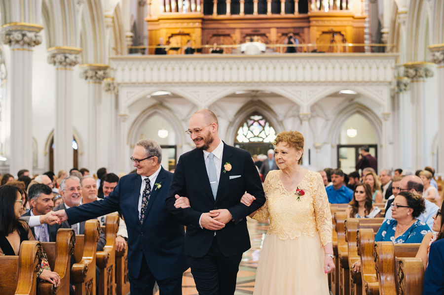 groomsmen walking grandparents down the aisle