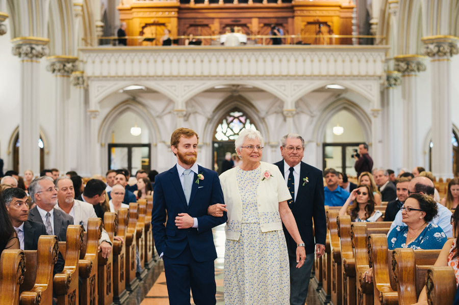 groomsmen escorting grandmother down the aisle