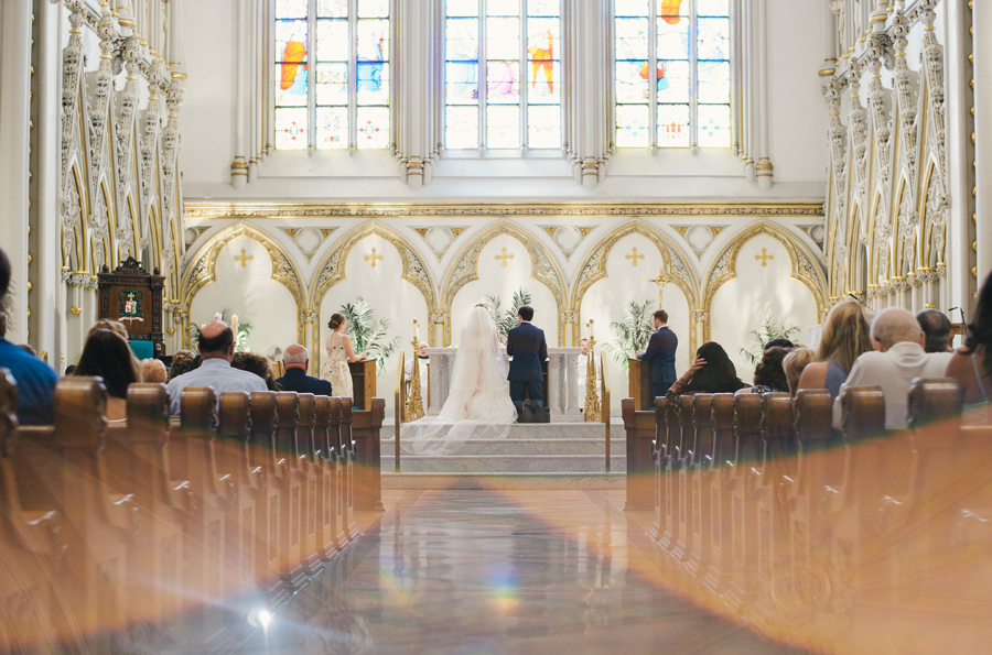 bride and groom kneeing at the altar of st joseph cathedral