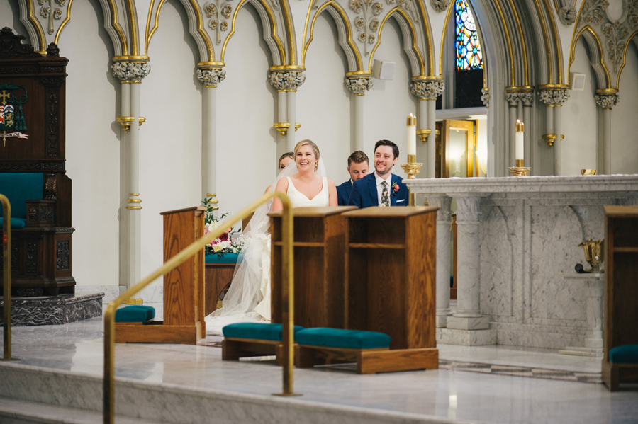 bride and groom laughing at the altar