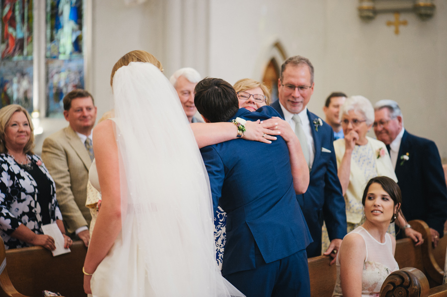 groom hugging the brides mother at the church