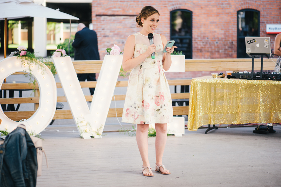 maid of honor reading speech off her phone at reception