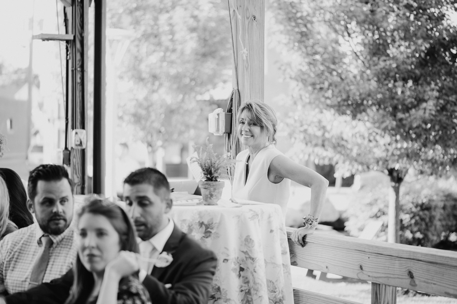 black and white photo of mother of the groom smiling during speeches