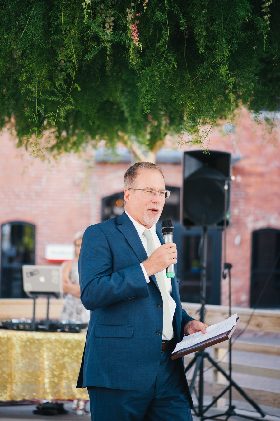 bride's father giving a speech under the greenery canopy by west wind floral