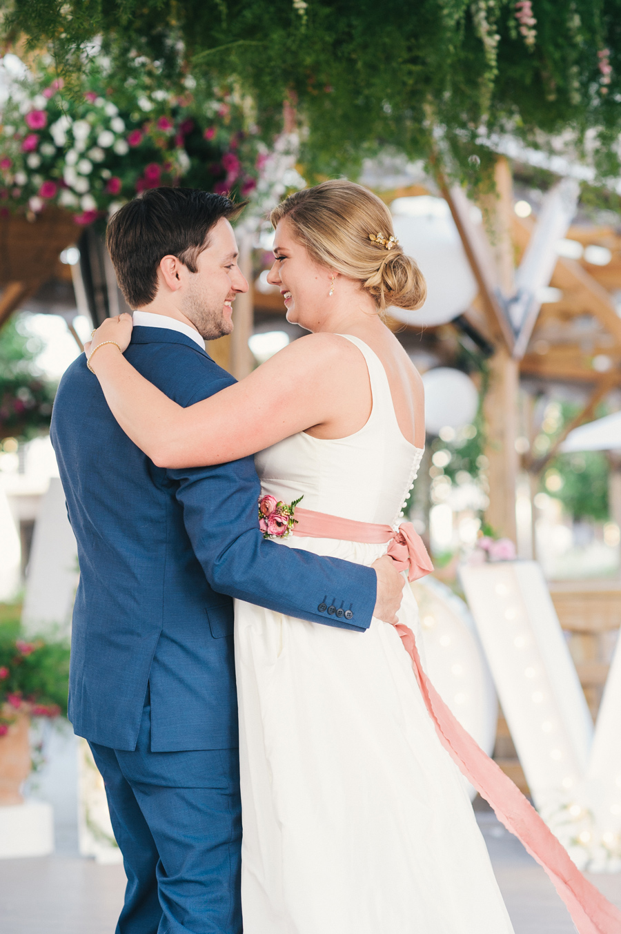 bride and groom's first dance under greenery canopy