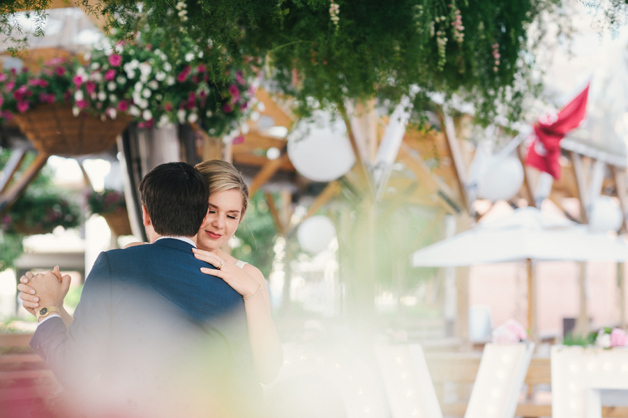 bride and groom slow dancing surrounded by flowers and greenery