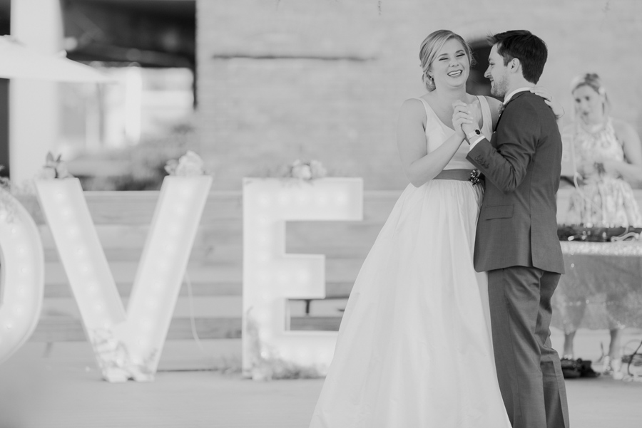 black and white photo of bride laughing during the first dance