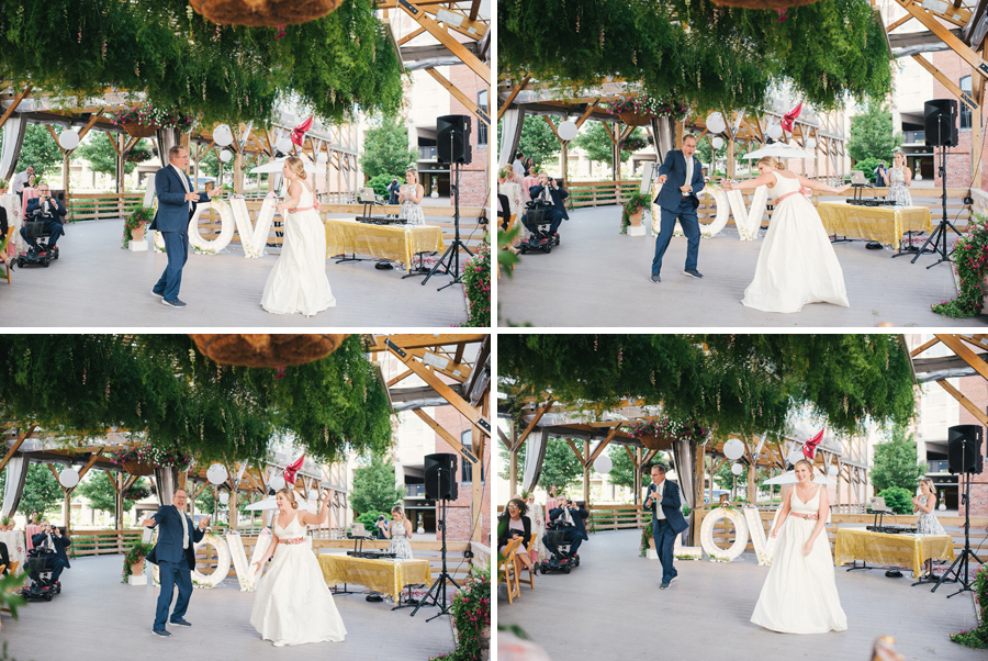 bride and her father having fun dancing together under greenery canopy