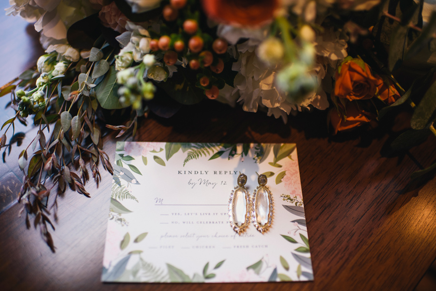 rsvp card with bride's earrings and bouquet