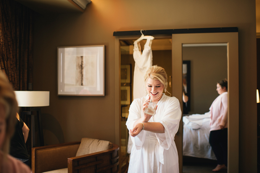 bride applying perfume to her wrists in curtiss hotel suite