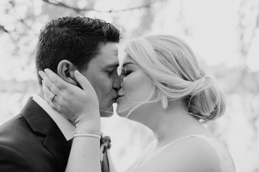 black and white of bride and groom kissing