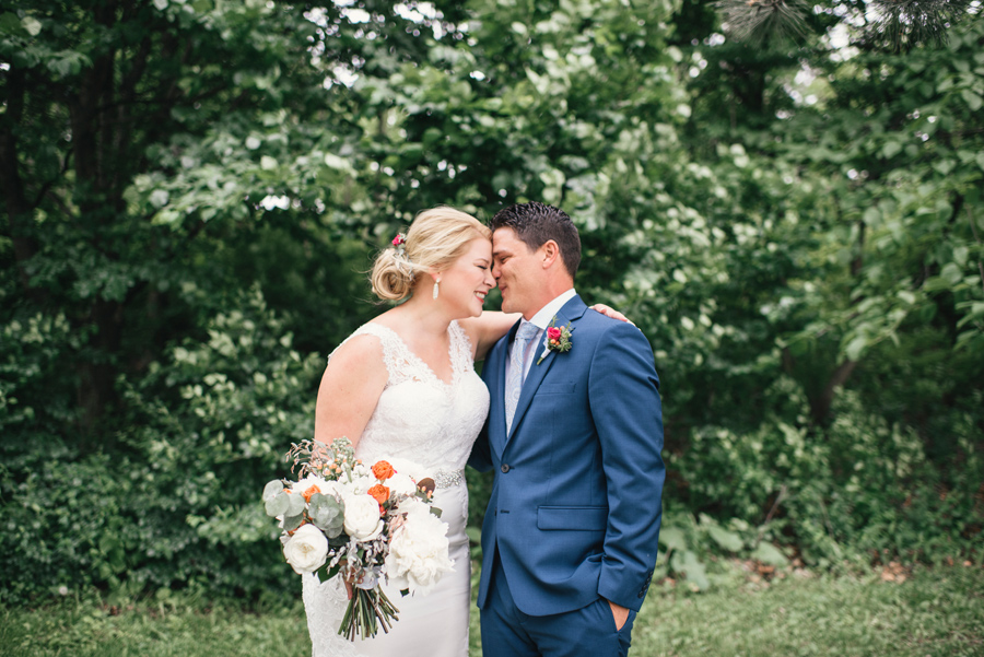 bride and groom laughing together in the park