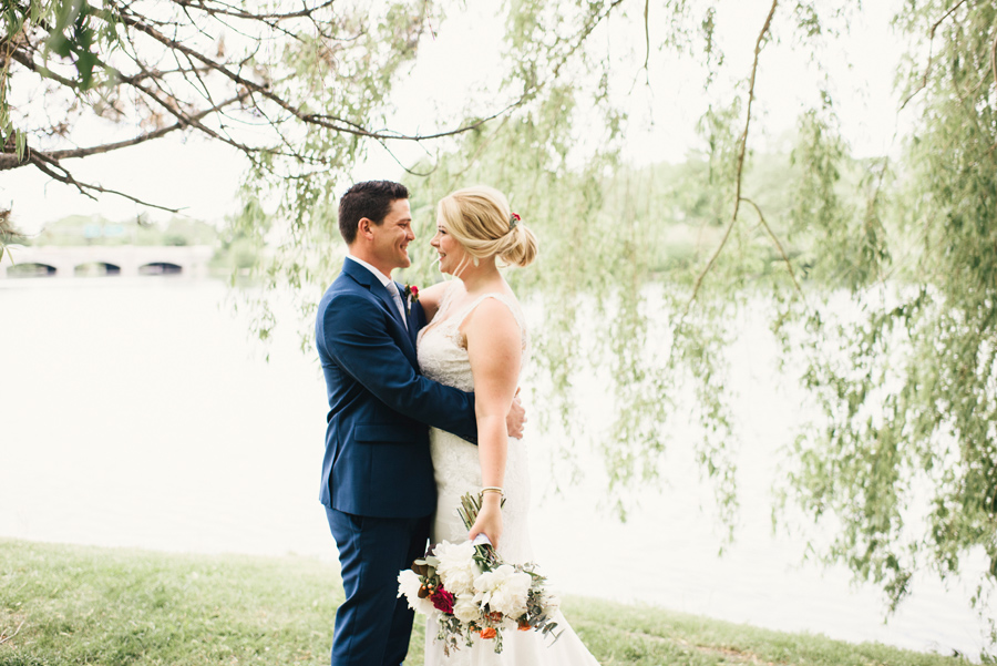 bride and groom smiling at each other next to hoyt lake