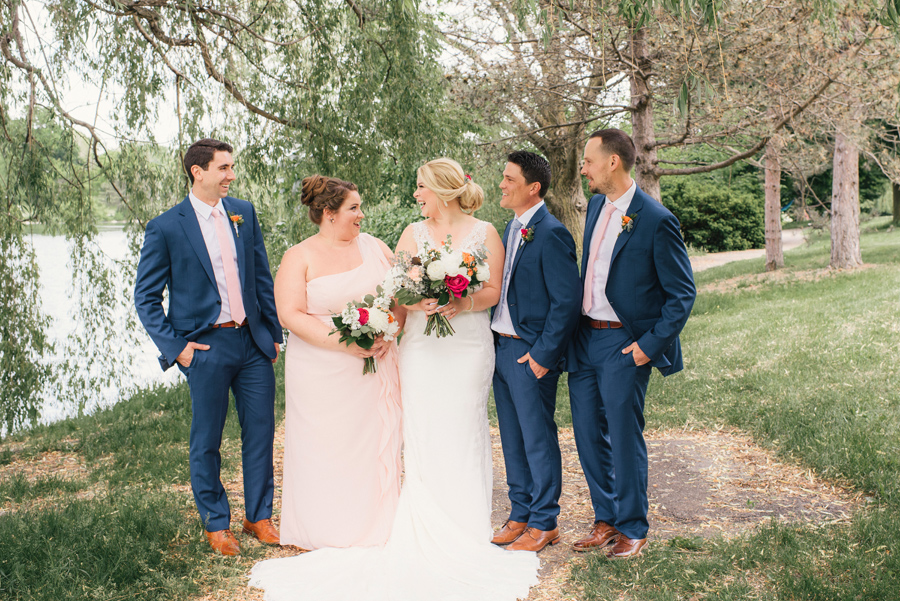 wedding party laughing together under a willow tree