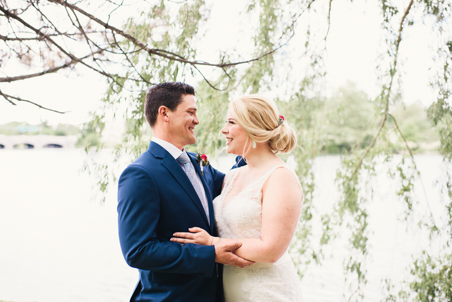 bride and groom smiling together under a willow tree