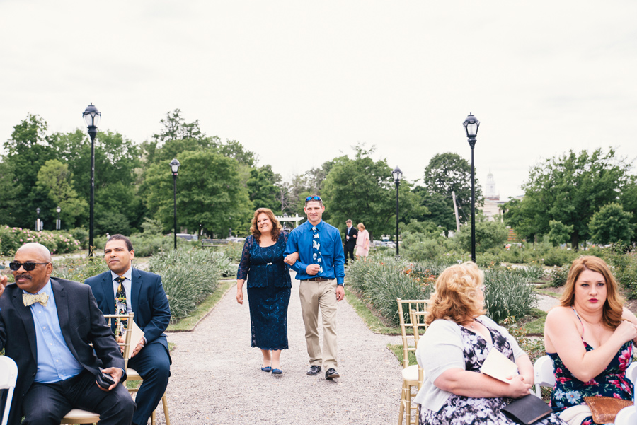 mother of the groom being escorted down the aisle