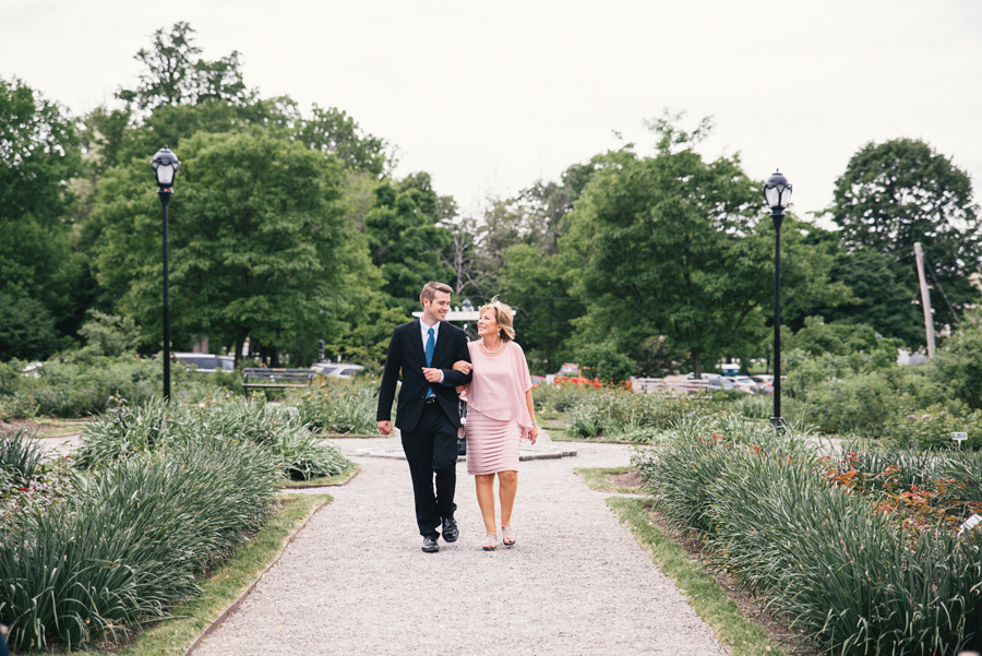 mother of the bride being escorted by her son down the aisle