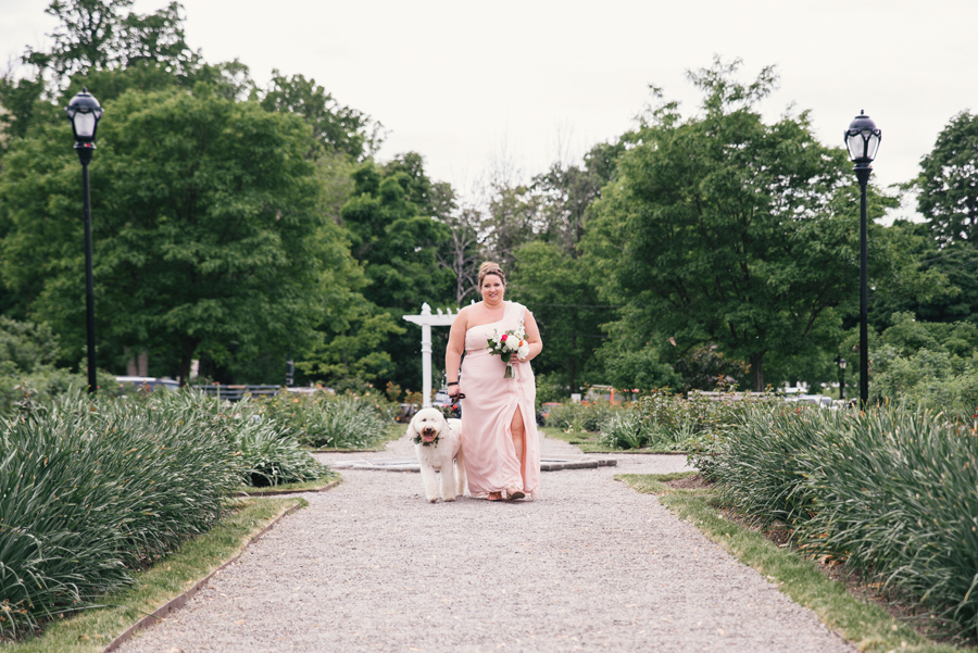 maid of honor walking down the aisle with bride and groom's dog