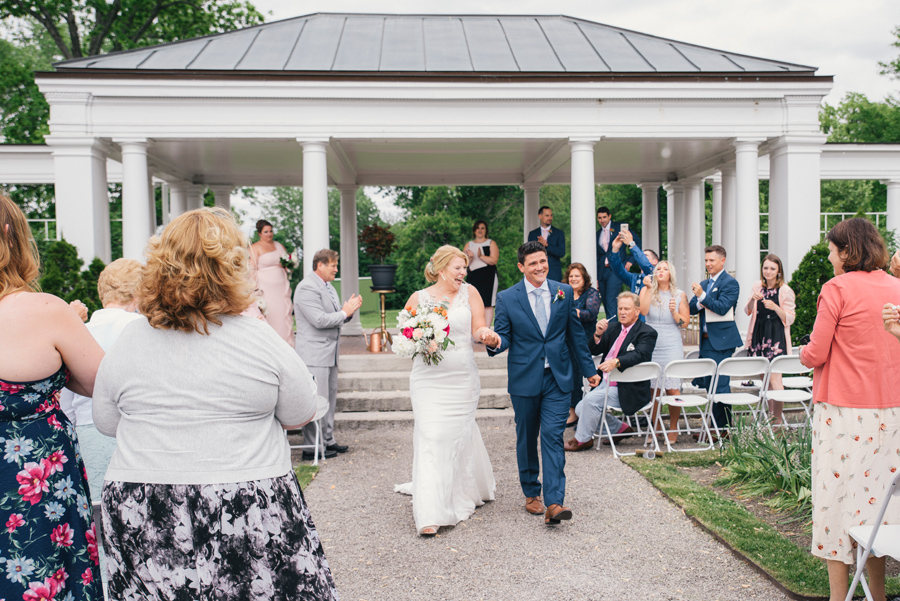 bride and groom smiling as the walk up the aisle