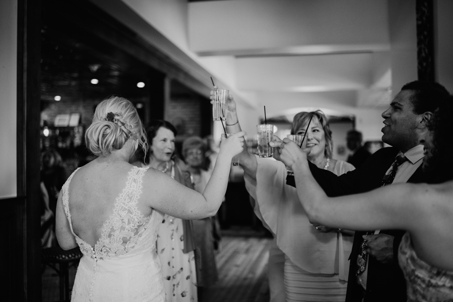 bride and wedding guests toasting each other at cocktail hour