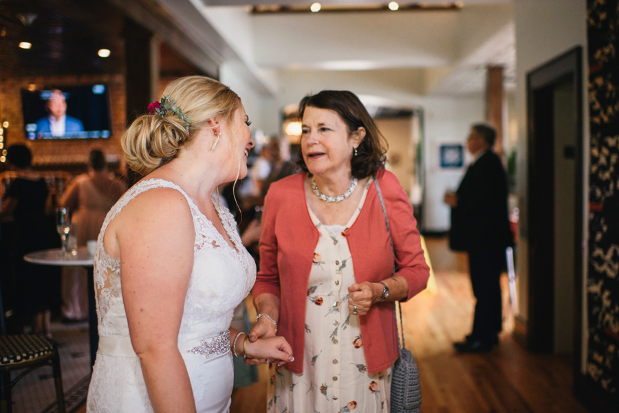 bride chatting with a wedding guest during cocktail hour