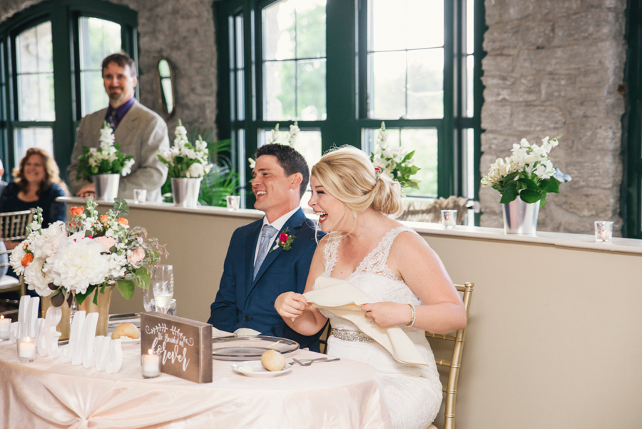 bride and groom laughing during mad of honor speech