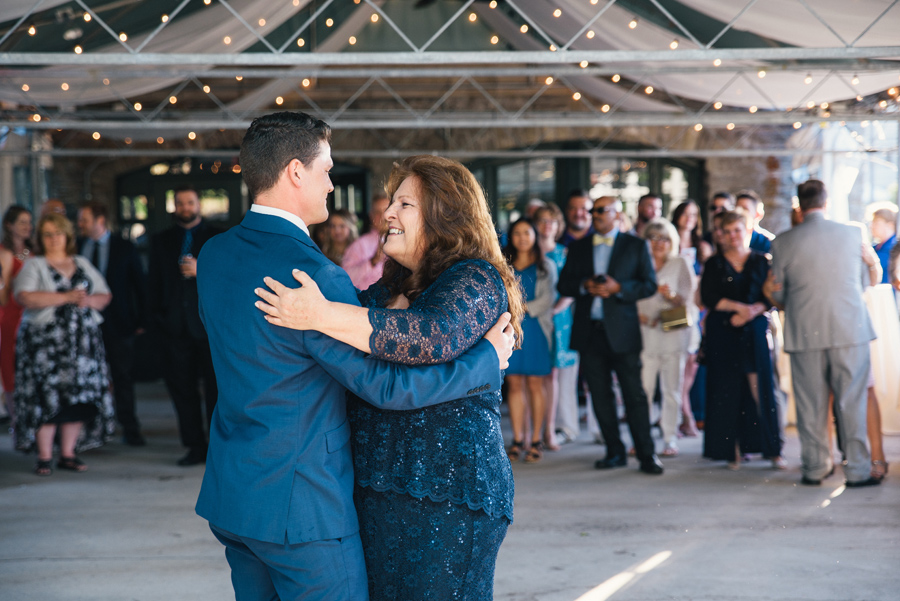 mother of the groom and her son smiling on the dance floor