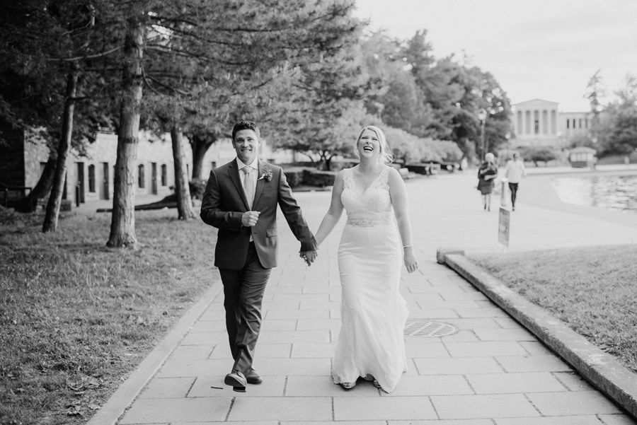 black and white of bride and groom walking together along hoyt lake