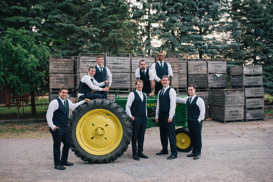 groom and groomsmen posing with restored 1941 john deere tractor