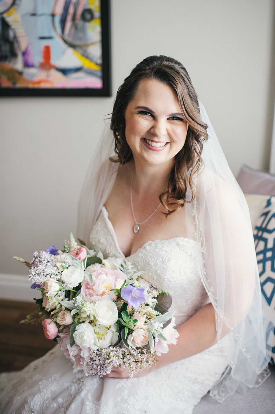 portrait of bride with her veil on and holding bouquet