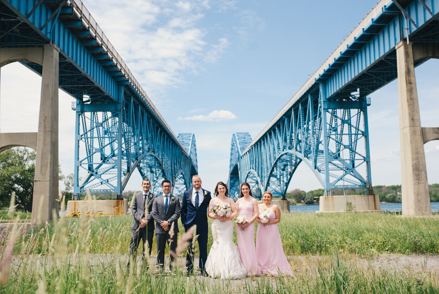 wedding party posing under the grand island bridge